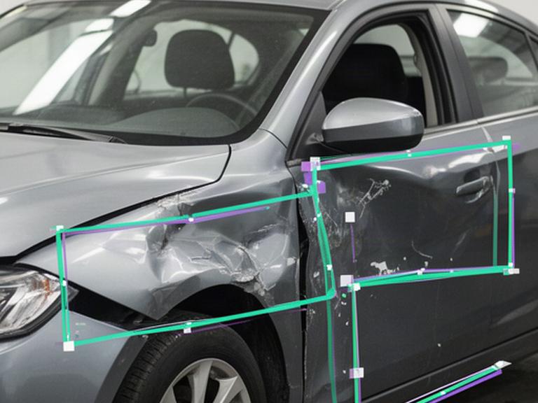 Beschadigde wagen voor een schadeanalyse met duidelijke AI-detectiekaders op de carrosserie